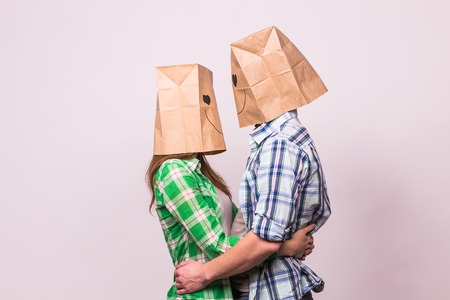 Valentine's day concept - Young love couple with bags over heads on white background.の写真素材