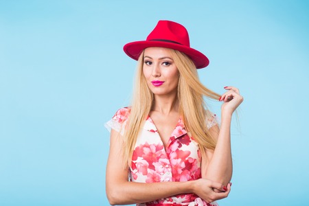 beauty fashion summer portrait of blonde woman with red lips and pink dress on blue background with copy spaceの写真素材
