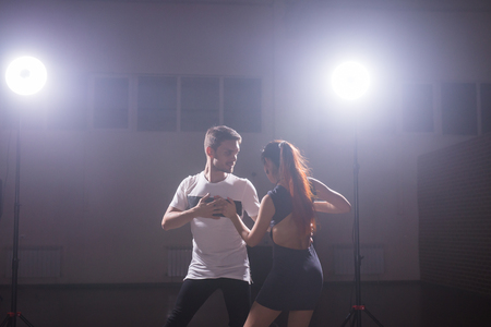 Young couple dancing social danse kizomba or bachata or semba or taraxia in dancing class backgroundの写真素材