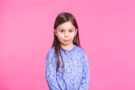 Portrait of a charming brunette little child girl, isolated on pink backgroundの写真素材