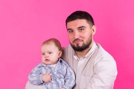 Baby in the daddy hands. Pink background.の写真素材