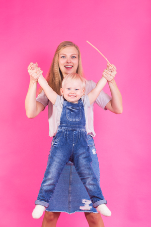 Funny family on pink background. Mother and her daughter girl. Mom and child are having fun.の写真素材