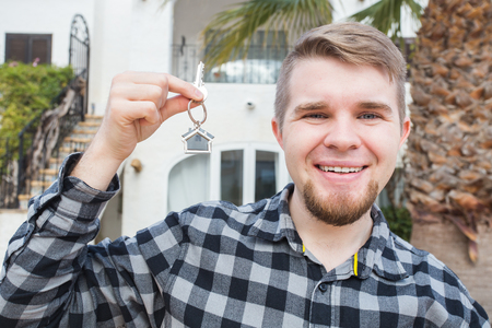 Young happy man showing a house keyの写真素材