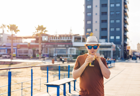 man with coffee frappe near sea feeling free enjoying freetime vacationsの写真素材