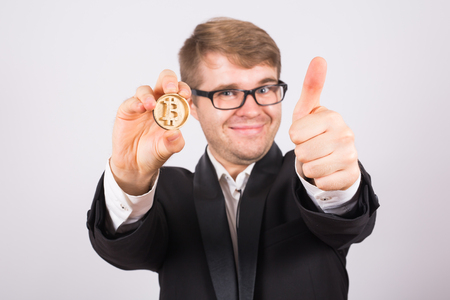 happy man holding big bitcoin and showing thumbs upの写真素材