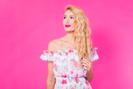Fashion photo of a beautiful elegant young woman in a pretty dress posing over pink background. Fashion spring summer photoの写真素材