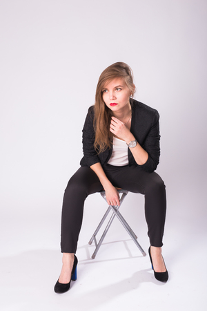 Caucasian attractive female model with brunette hair posing in studio, wearing formal suit isolated on white backgroundの写真素材