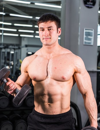 Muscular bodybuilder guy in gymの写真素材
