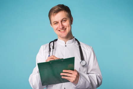 Medical doctor writing prescription over blue background.