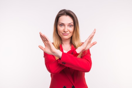 Portrait of young european woman in red jacked in studio with crossed hands.