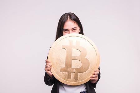 Asian woman holding big bitcoin on white background. Cryptocurrency investment concept.の写真素材