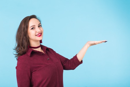 Confident young woman standing over blue background with copyspaceの写真素材