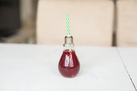 Organic red orange juice in a glass in the form of a light bulb.
