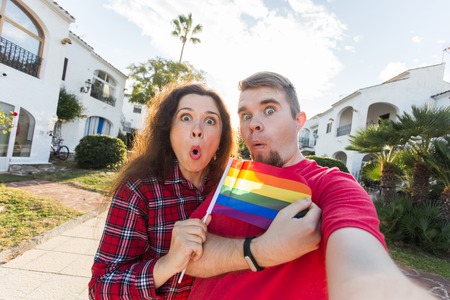Gay and lesbian friendship holding rainbow flagの写真素材