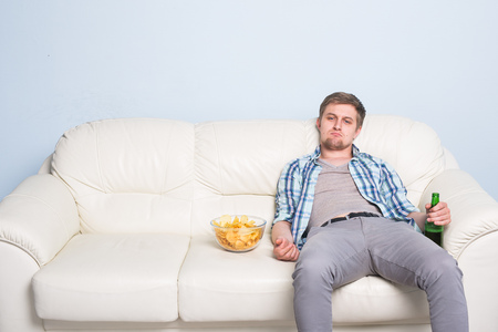 Sad man or football fan watching soccer on tv. Losing a favorite teamの写真素材
