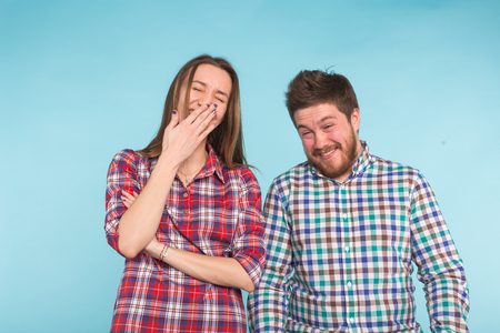 Funny young couple laughing and fooling around together on blue background.の写真素材