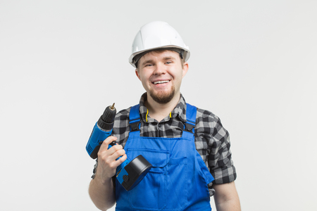 Close-up of handsome male builder with screwdriver wearing white helmet.の写真素材