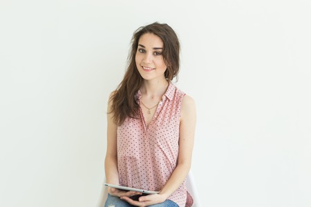Business, technology and people concept - close up portrait of young woman holding a tablet on white...