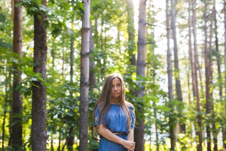 Nature, summer and people concept - Portrait of romantic young woman in forest