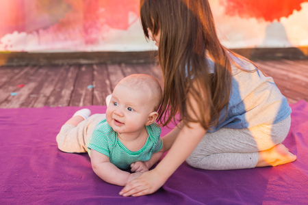 Cute child baby boy and his sister lying on blanket in summer day on nature. Family picnic in a park.の写真素材