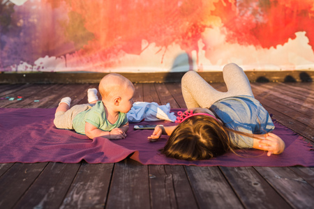 Cute child baby boy and little girl lying on blanket in summer day on nature. Brother and sister conceptの写真素材