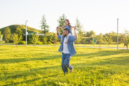 Fatherhood, family and children concept - Father and daughter having fun and playing in nature.の写真素材