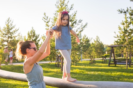 Family and child concept - Mother and daughter walking and playing in the park and enjoying the beautiful nature.の写真素材