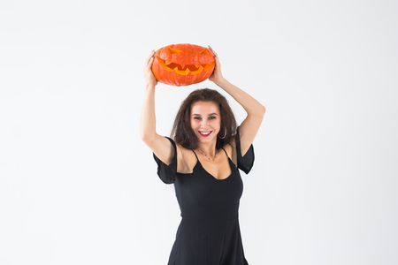 Halloween and holidays concept - Witch woman with Jack OLantern pumpkinの写真素材