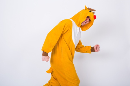 People, holidays and christmas concept - young man in Santa Claus deer costume dancing on white backgroundの写真素材