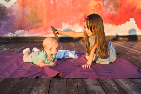 Cute child baby boy and little girl lying on blanket in summer day on nature. Brother and sister...