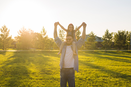 Fatherhood, family and children concept - Father and daughter having fun and playing in nature.の写真素材