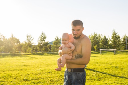 Happy father holding baby son on nature. Concept of happy family, fathers day and child.の写真素材