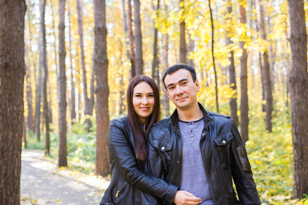 Love, relationship, family and people concept - smiling couple hugging in autumn parkの写真素材