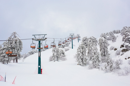 Cyprus Ski lifts and cable cars going up the mountain bringing snowboarders to ski slopes.の写真素材