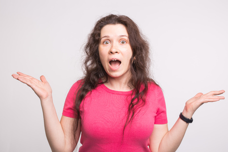 Excited screaming young woman standing isolated over white background.の写真素材
