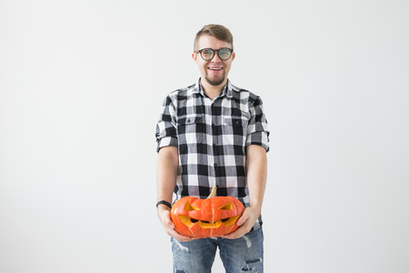 Halloween, holidays, autumn and people concept - Happy man holding a jack-o-lantern pumpkin.の写真素材