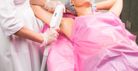 Spa, people and cosmetology concept - Woman having underarm laser hair removal epilationの写真素材