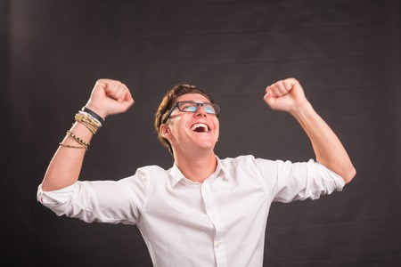 Emotions, gesture and people concept - Handsome happy man in white shirt over grey backgroundの写真素材