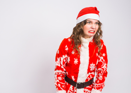 Holiday, Christmas and people concept - Angry woman in santa costume on white backgroundの写真素材