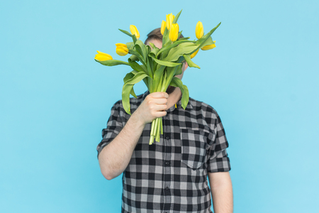 Men in studio with bunch of flowers instead headの写真素材