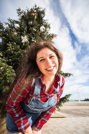 Christmas, holidays, humor and people concept - young happy woman have fun under the christmas treeの写真素材