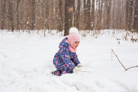 Childhood and nature concept - Adorable child playing in winter parkの写真素材