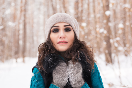 Winter, season and people concept - Portrait of young woman walking in snowy parkの写真素材