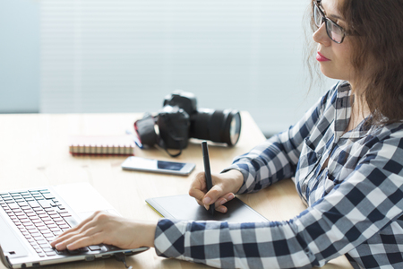 Business, technology and people concept - woman use designer tablet in working at laptopの写真素材