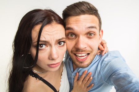Relationship and family concept - happy funny couple taking selfie on white backgroundの写真素材
