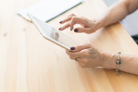 People and technologies concept - Close up of womans hands holding digital tabletの写真素材