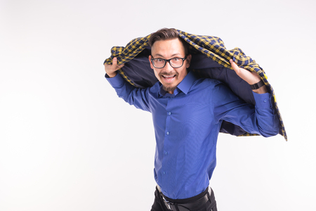 Expression and funny people concept - Portrait of smiling man with jacket on his head on white backgroundの写真素材