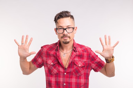 Emotions and people concept - handsome man showing you his hands or scares you, wearing checkered...