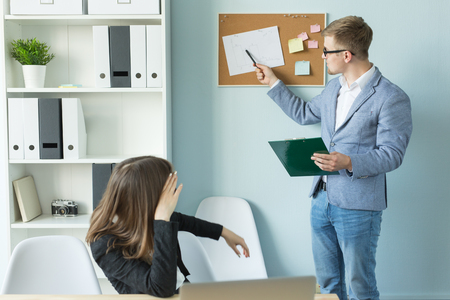 Business, team work and people concept - woman and man are discussing their project together in officeの写真素材