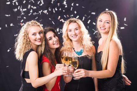 Party, holidays, celebration and new year eve concept - Cheerful young woman clinking glasses of...